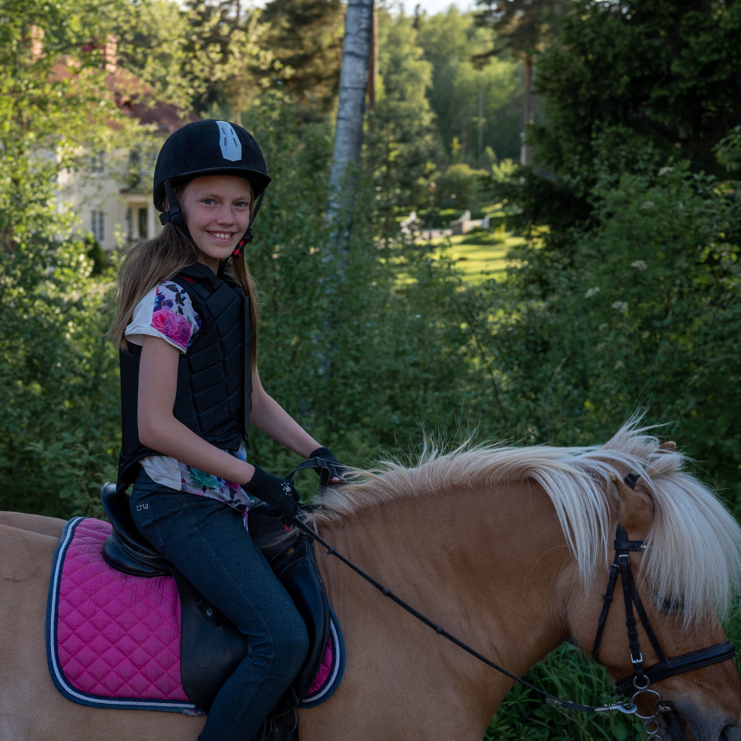 Flicka rider ponny i skogen